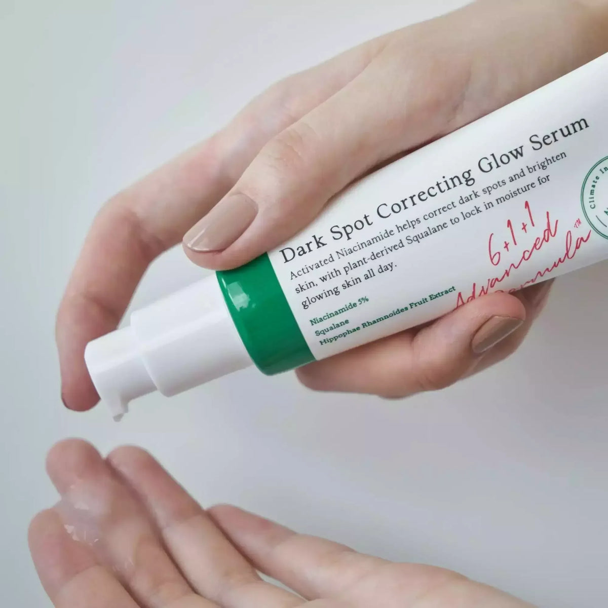 Main pressant le sérum AXIS-Y Dark Spot Correcting Glow au-dessus de l'autre main