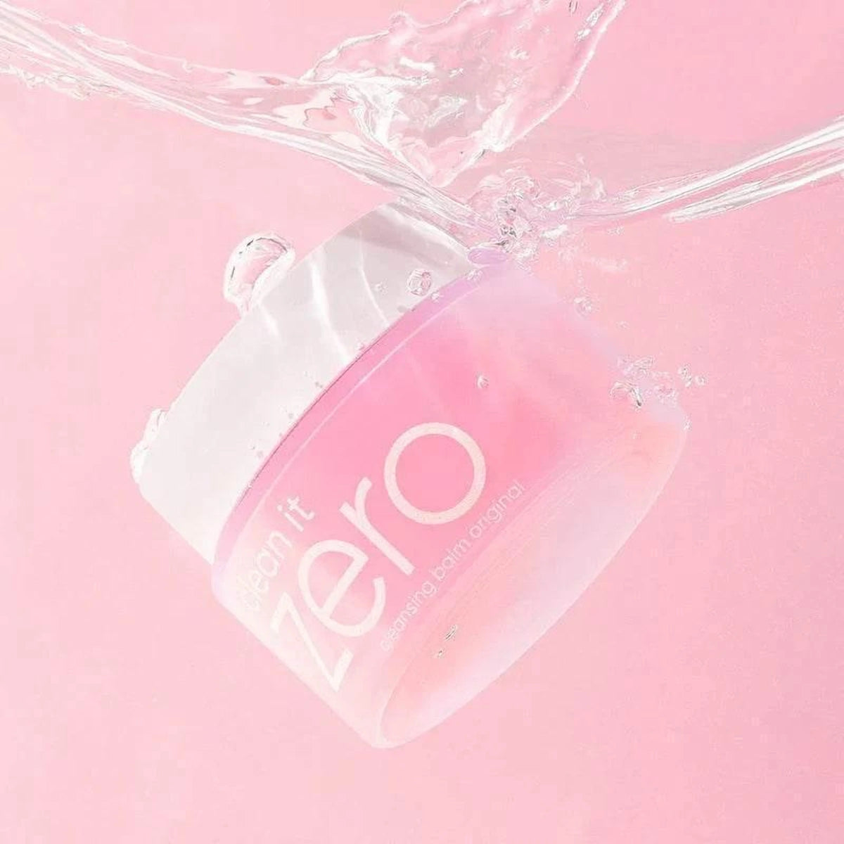 Pot du baume démaquillant Banila Co Clean It Zero plongé dans une eau claire, fond rose
