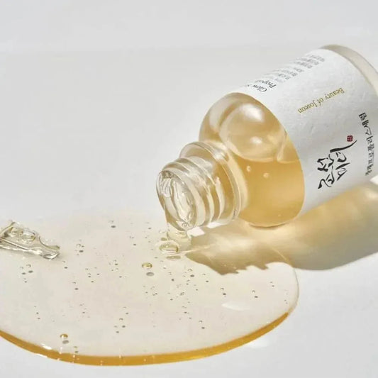 Flacon couché du sérum Beauty of Joseon Glow Propolis laissant couler une texture dorée