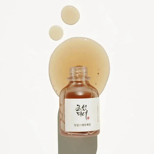 Gouttes de texture ambrée au-dessus du flacon ouvert du sérum Beauty of Joseon Revive Ginseng