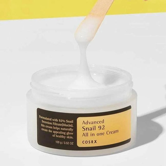 Spatule soulevant la texture gel blanche de la crème COSRX Advanced Snail 92 dans le pot ouvert