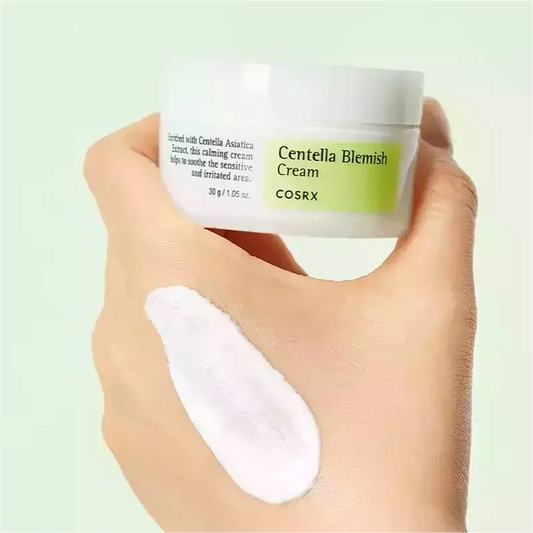 Main tenant le pot de la crème COSRX Centella Blemish, trace de crème blanche sur le dos de la main