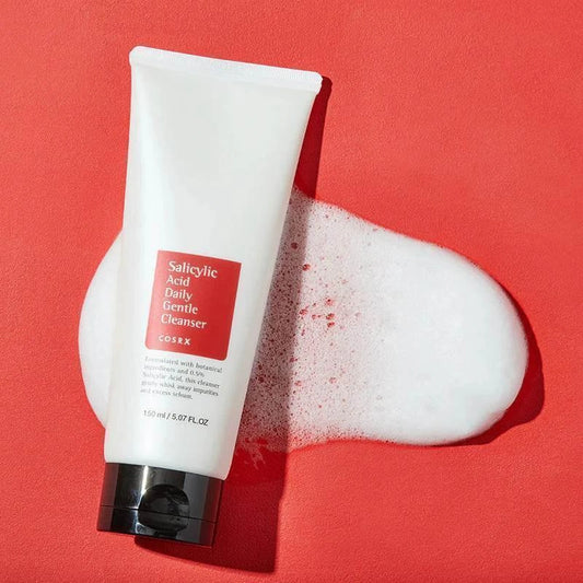 Tube du gel nettoyant COSRX Salicylic Acid posé sur une mousse blanche, fond rouge