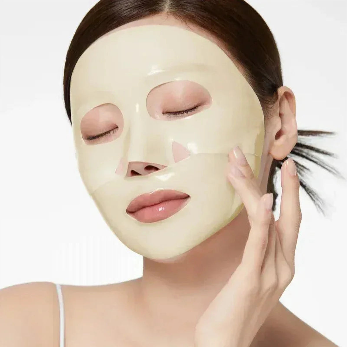 Femme aux yeux fermés portant le masque gel jaune pâle Medicube Kojic Acid Turmeric sur le visage