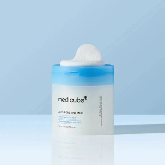 Pot des pads Medicube Zero Pore Pad Mild avec un disque de coton posé sur le dessus, fond bleu