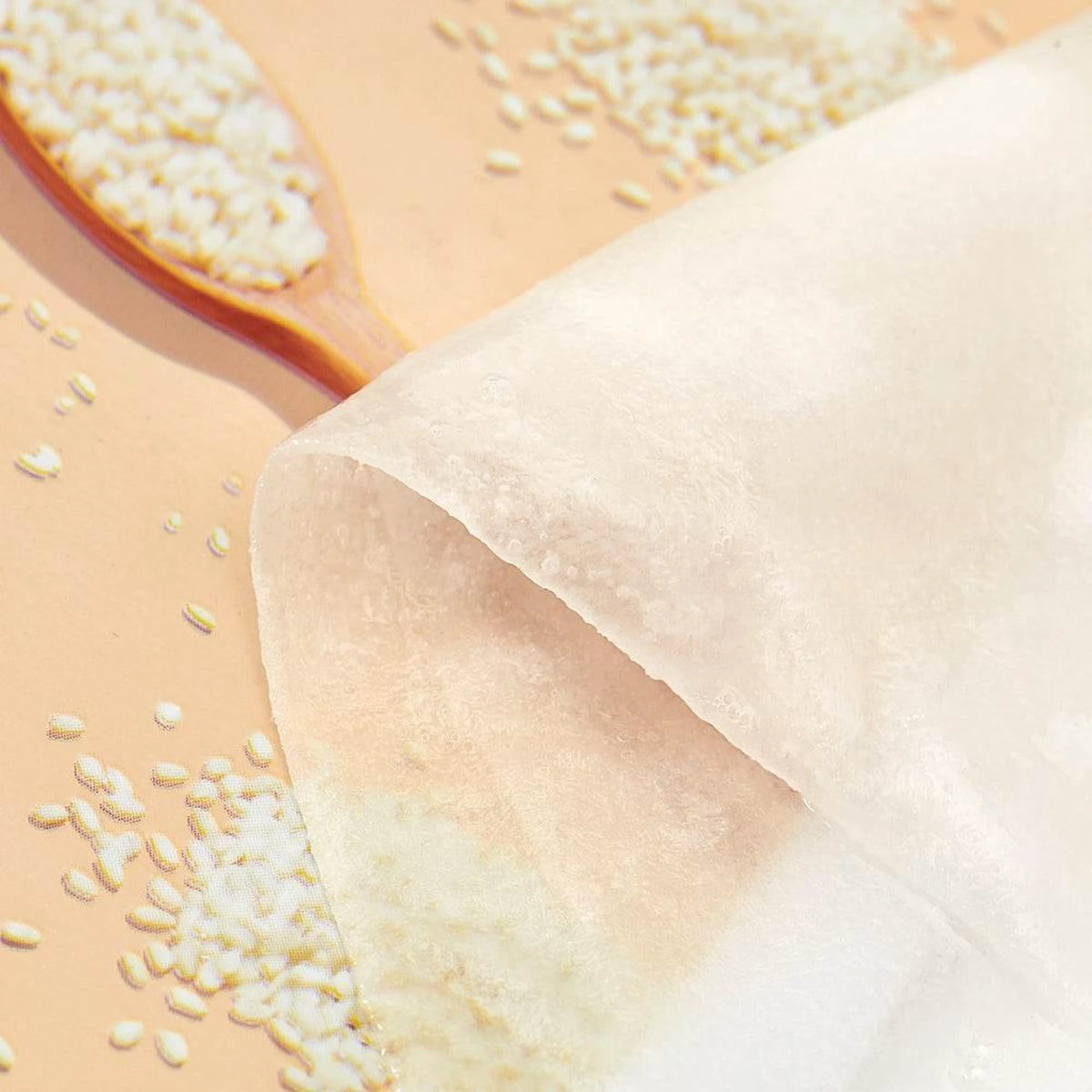Gros plan sur la fibre fine du masque en tissu Missha Airy Fit Riz posé sur des grains de riz