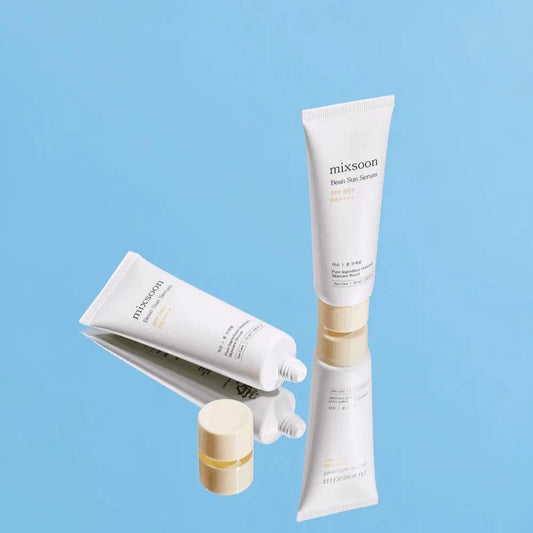Tubes de la crème solaire Mixsoon Bean Sun Serum en suspension sur fond bleu ciel
