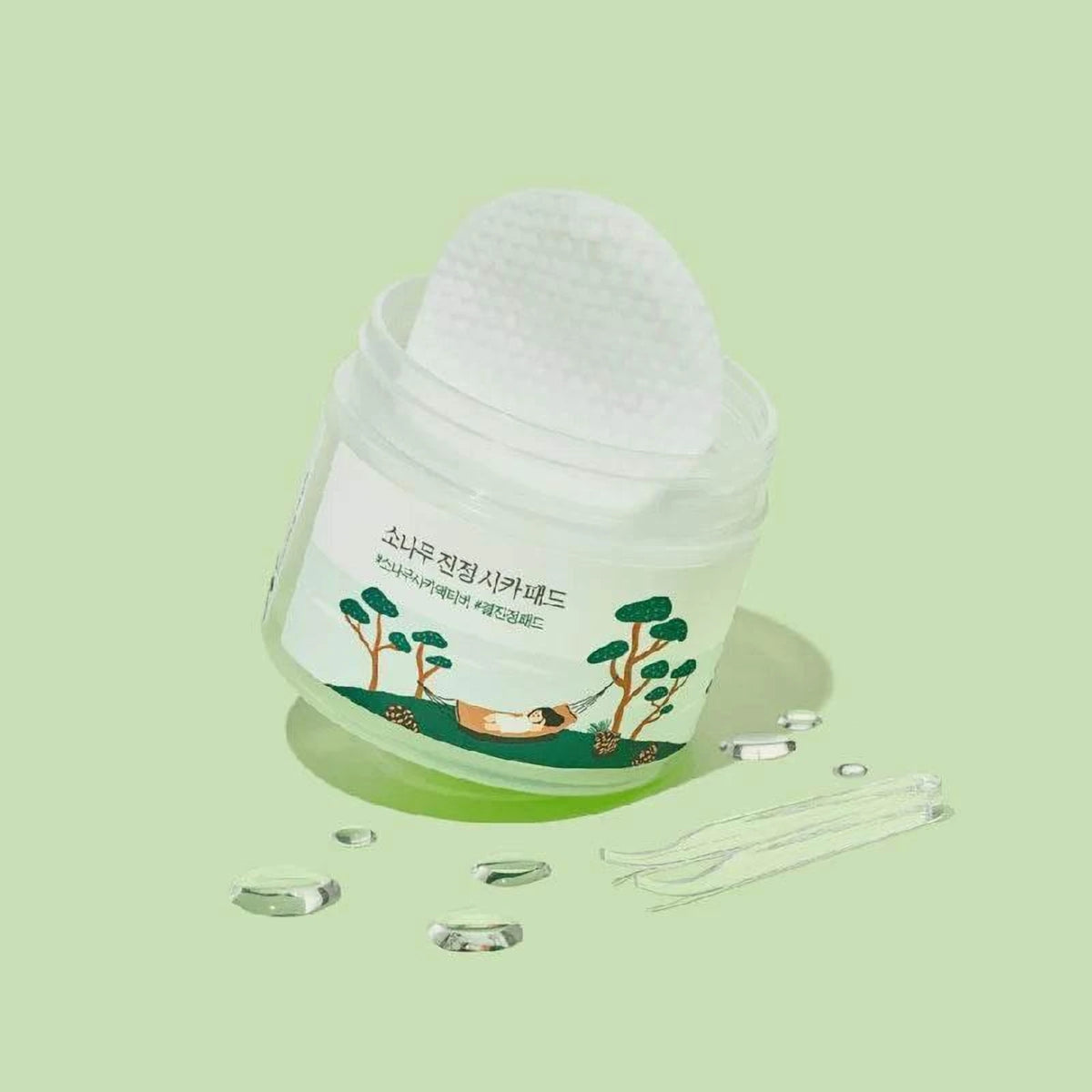 Pot ouvert des pads Round Lab Pine Calming Cica avec un pad soulevé, fond vert clair