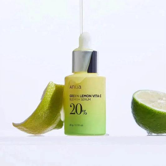 Flacon du sérum Anua Green Lemon Vita C entre deux moitiés de citron vert