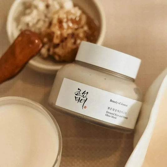 Pot du masque Beauty of Joseon Ground Rice and Honey près d'un bol de riz et d'une cuillère à miel