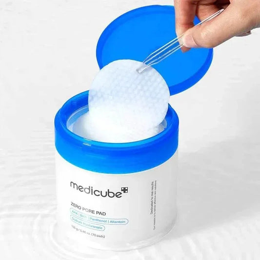 Pince sortant un pad du pot ouvert des Medicube Zero Pore Pad posé dans l'eau