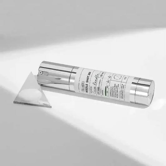 Flacon couché du sérum VT Reedle Shot 300 près d'un prisme de verre sous la lumière